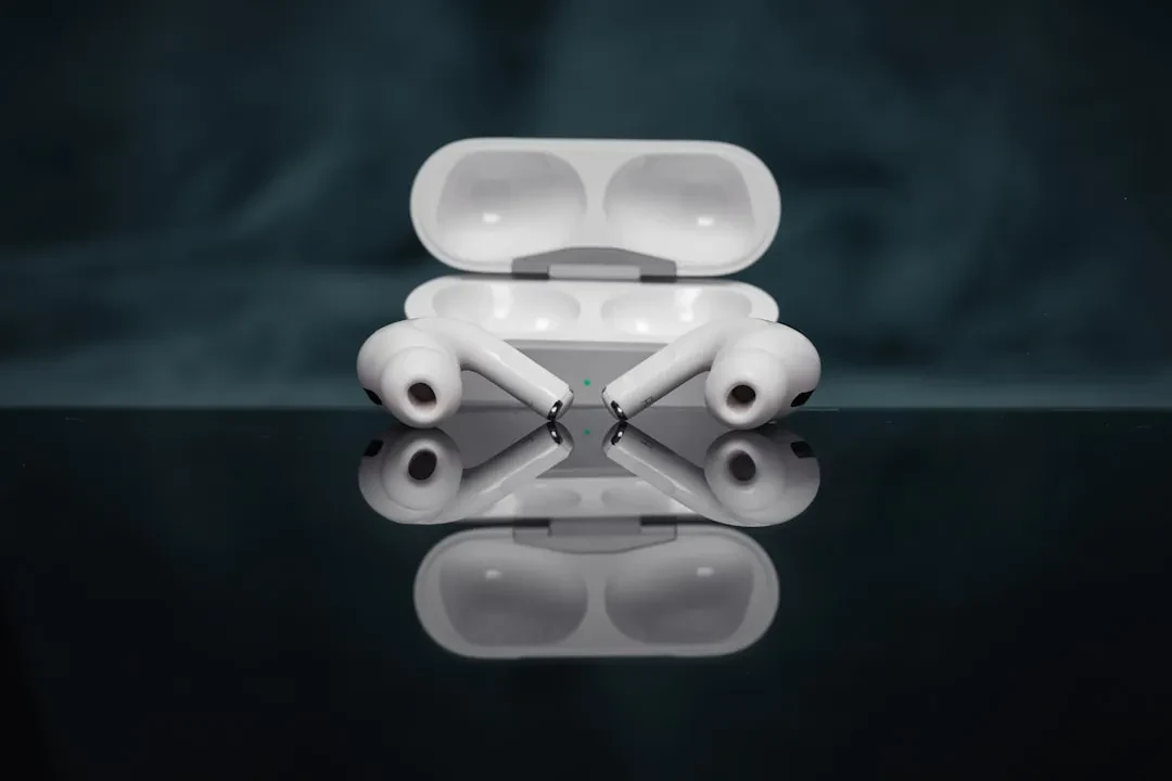 AirPods Pro com o estojo de carga aberto, refletidos sobre uma superfície escura e brilhante