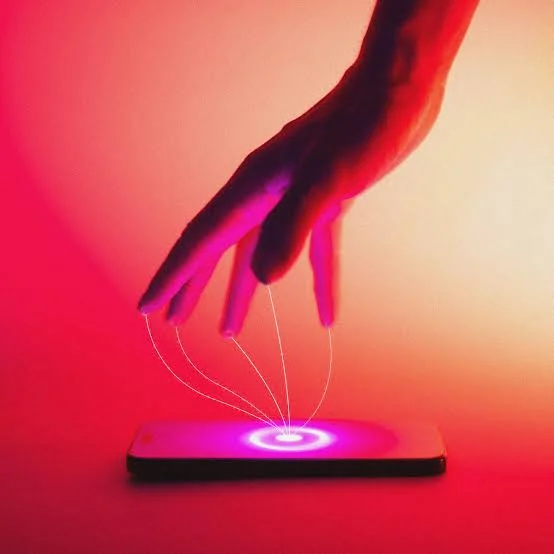 Mão controlando um celular por fios luminosos, como uma marionete, sobre fundo vermelho e rosa