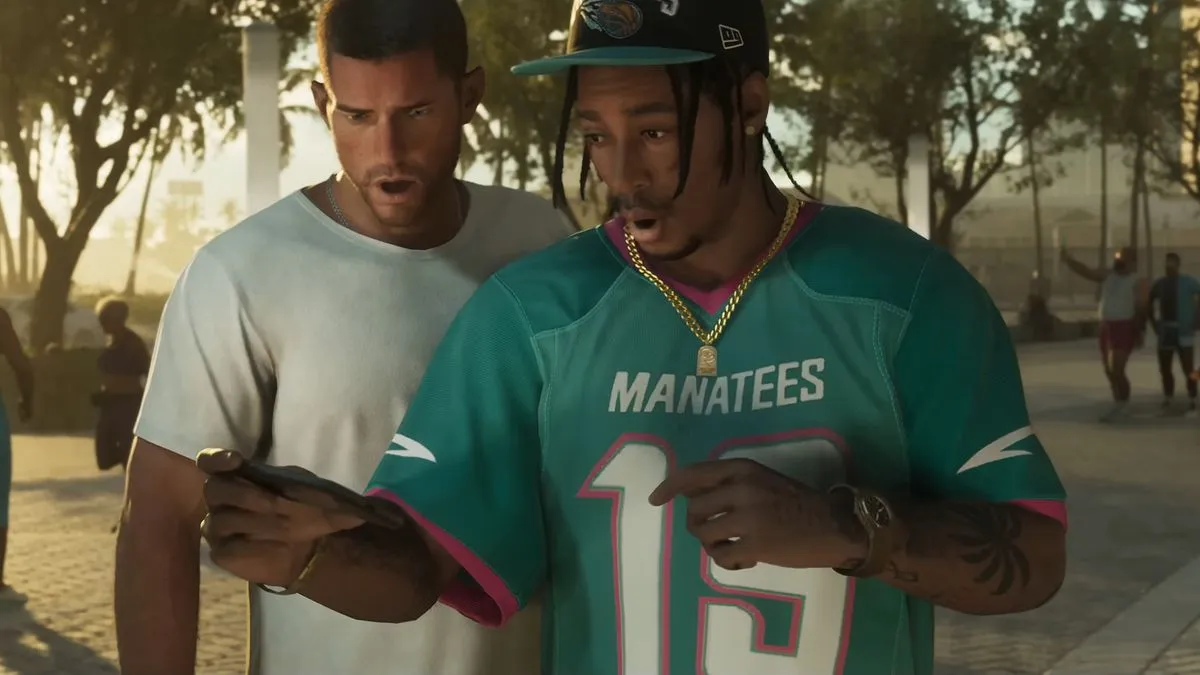 Dois personagens de GTA 6 olham para a tela de um celular com expressão de choque, em uma praça ensolarada de Vice City