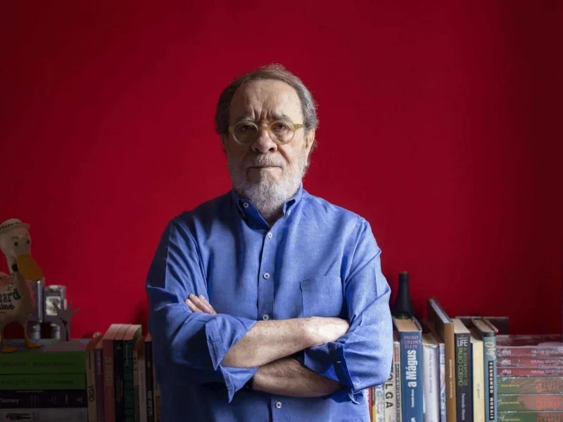 Fernando Morais em frente à estante com seus próprios livros
