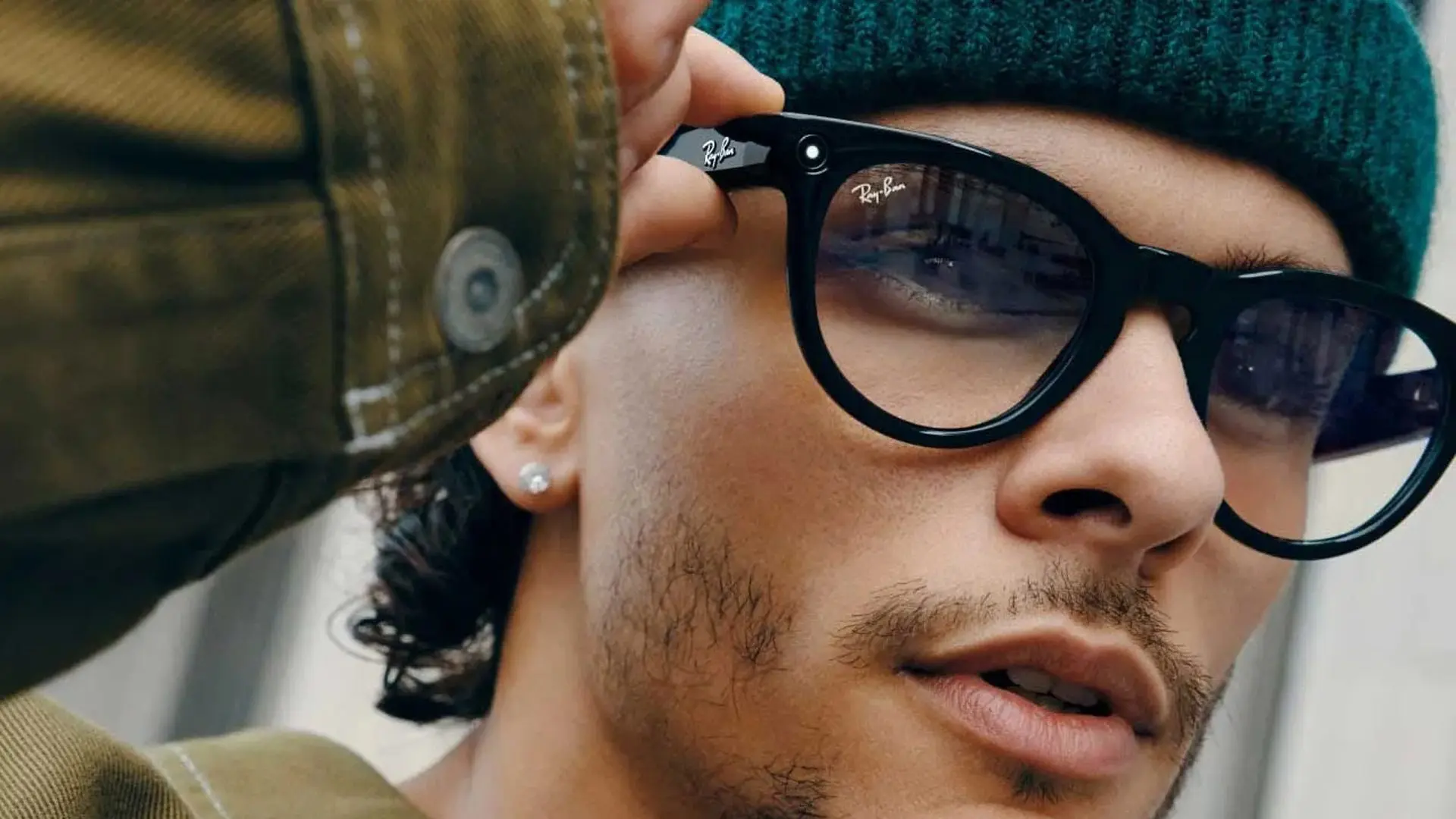 Homem usando óculos inteligentes Meta Ray-Ban pretos em close, câmera embutida visível na armação