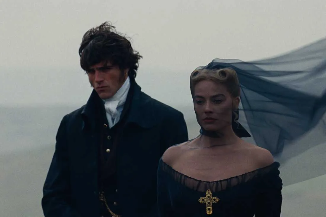 Jacob Elordi e Margot Robbie como Heathcliff e Catherine nos campos ventosos em cena de O Morro dos Ventos Uivantes