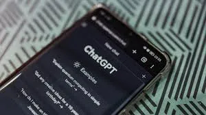 Tela do aplicativo do ChatGPT em um celular, com o logotipo da OpenAI ao fundo