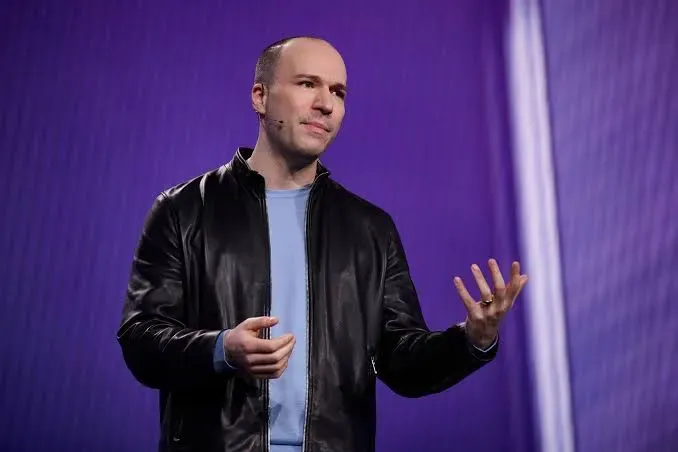 Greg Brockman, presidente da OpenAI, em palestra com fundo roxo