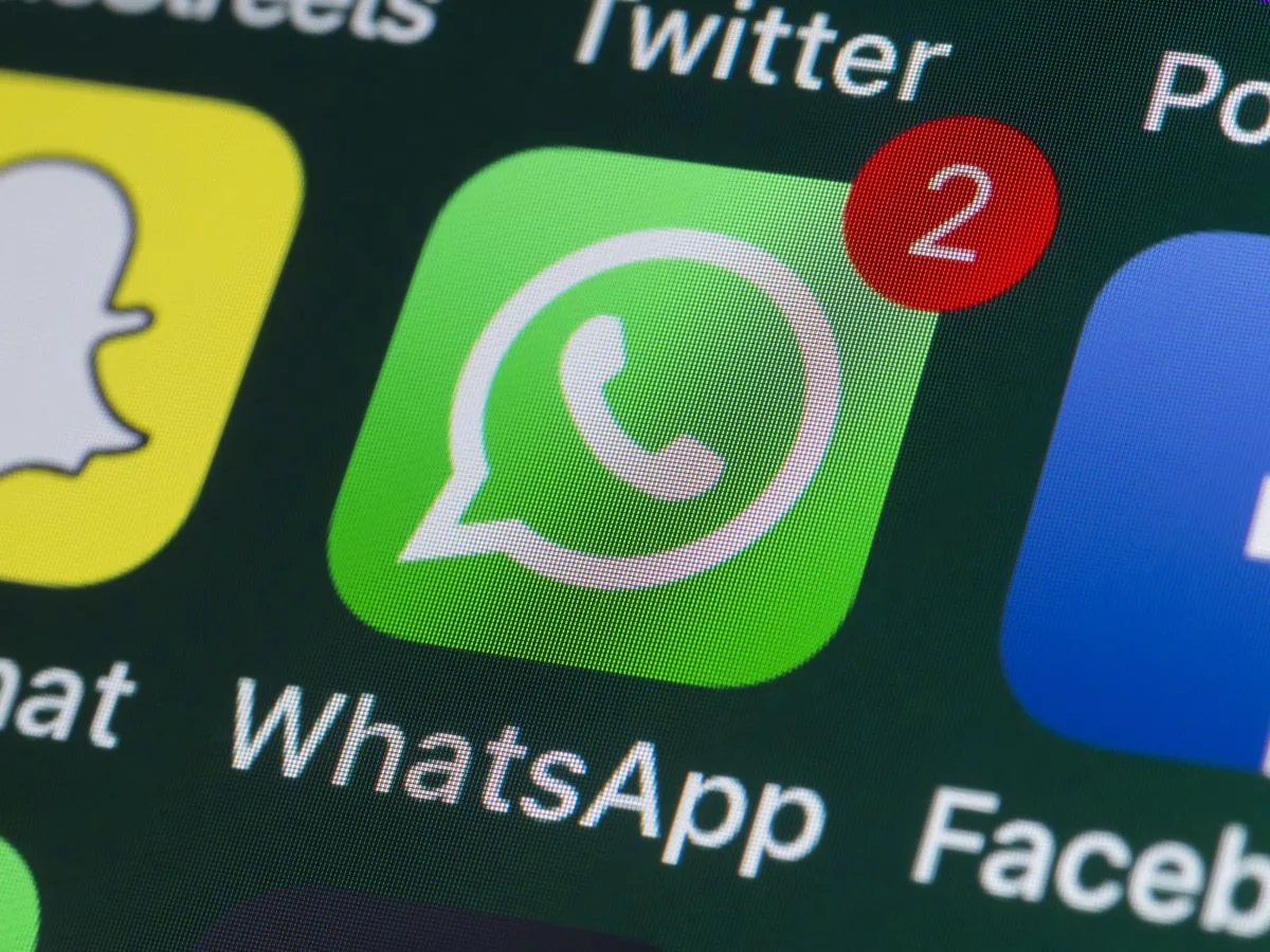 Tela do WhatsApp em um iPhone com ícone de cadeado e arquivos de banco de dados em destaque